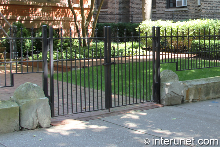 fence with steel gates painted black in combination with stones