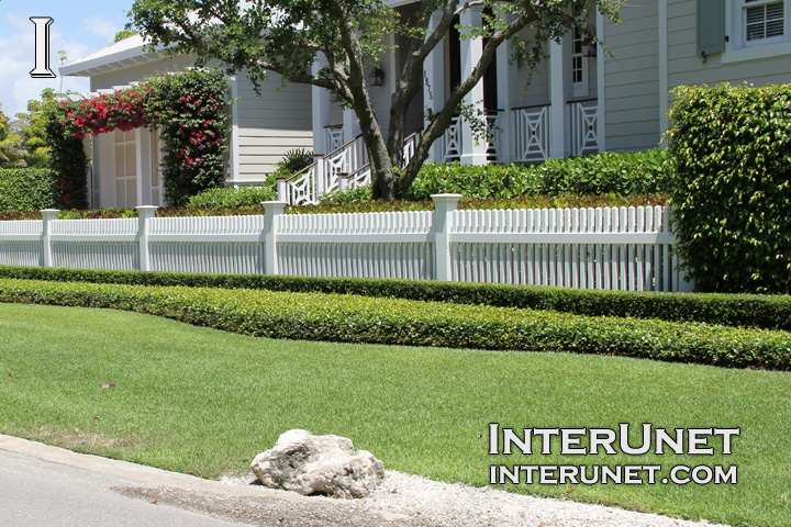 low-white-picket-fence-with-beautiful-landscaping