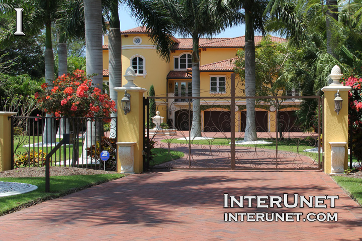 metal gates custom-welded-metal-gates-on-yellow-stucco-finished-pillars