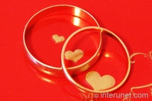 wedding rings wedding-rings-on-red-background-with-hearts