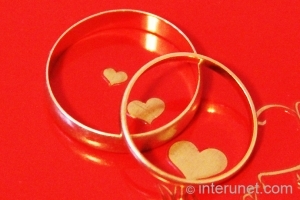 wedding-rings-on-red-background-with-hearts