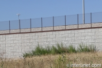 chain link fence on top of concrete blocks wall