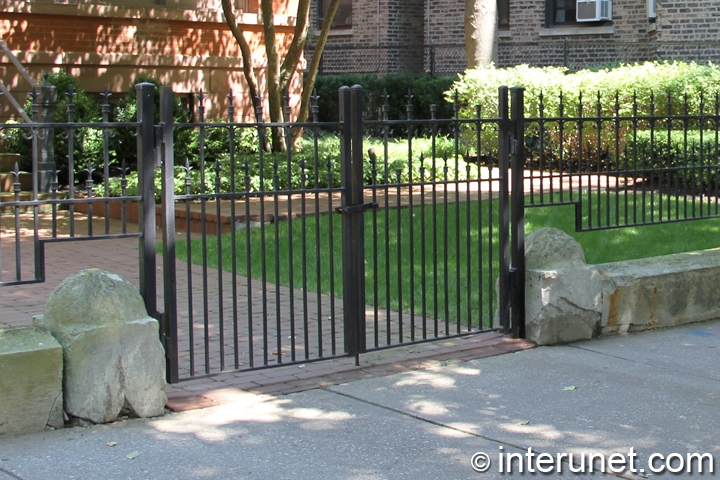 fence with steel gates painted black in combination with stones