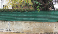 green-fence-over-concrete-blocks